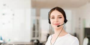 Customer support female employee wearing headphone and facing the camera